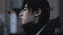 a close up of a man 's face with a black jacket on