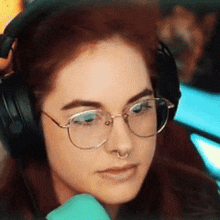 a woman wearing glasses and headphones is looking down