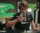 a man drinking a glass of water from a chess.com classic champions chess tour