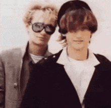 a man and a woman are standing next to each other wearing sunglasses .