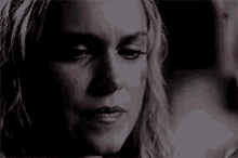 a close up of a woman 's face in the dark with a serious look on her face .
