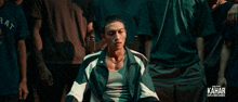a man in a green and white jacket says " dah "
