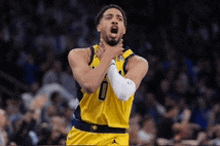 a basketball player in a yellow jersey is holding his hand to his mouth .