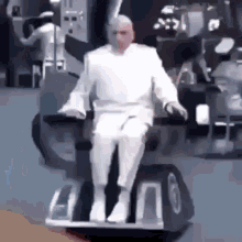 a man in a white suit is sitting on a wheelchair .