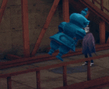 a man in a purple cape stands next to a statue