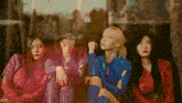 a group of girls are sitting next to each other in front of a window with the words aespagifs on the bottom
