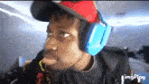 a man wearing headphones and a hat is making a face .