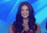 a woman is smiling in front of a blue background .