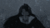 a person is standing in a dark room with a blue light coming out of the ceiling .