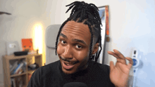 a man with dreadlocks and a mustache is smiling