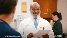a man in a white coat with st denis medical written on the front