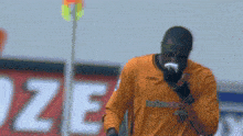 a soccer player wearing an orange totesport jersey