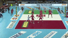 a volleyball game is being played on a court with advertisements on the floor
