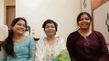 three women are sitting next to each other and smiling for a picture