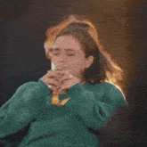 a woman in a green sweater says " do it do it "