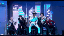 a group of men are dancing on a stage with a sign that says exit in the background