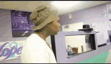 a man wearing a hat stands in front of a purple wall with the word hope on it