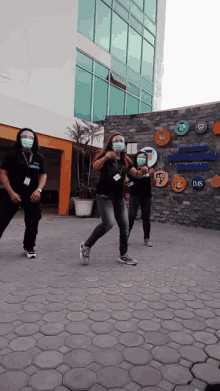 a group of people wearing face masks are dancing in front of a building that says instituto mexicano de estudios superiores