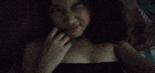 a woman is taking a selfie in the dark with her hand on her chin .