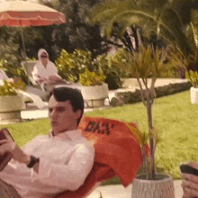 a man sits in a chair with an orange towel that says ' bar ' on it