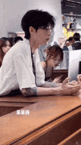 a man with a tattoo on his arm is sitting at a table