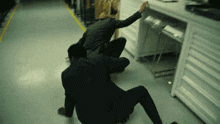 a man in a suit is crawling on the floor in an office .