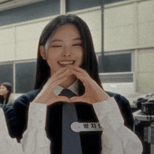 a girl making a heart shape with her hands and a name tag that says ' park ji-yeon '