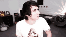 a young man wearing a white shirt with a triangle on it