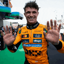 a man wearing a yellow and black racing suit with logos for allwyn and dell technologies