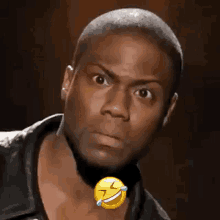 a close up of a man 's face with a laughing emoji on his neck .