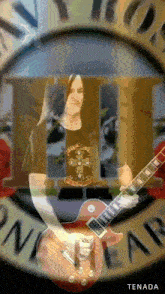 a man playing a guitar in front of a sign that says guns n roses