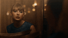a woman in a blue dress is smiling in front of a mirror