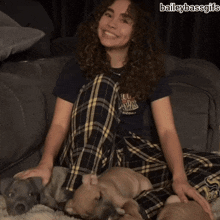 a girl with curly hair is sitting on a couch with a bunch of dogs and the caption baileybassgifs