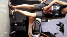 a man is sitting in a chair with his legs crossed and his hands on his hips .