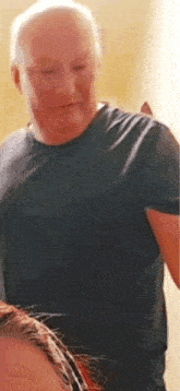 a man in a black shirt is standing next to a woman and looking at her .