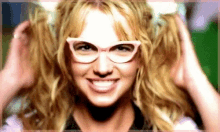 britney spears wearing glasses and pigtails smiles for the camera