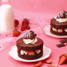 a chocolate cake with strawberries and whipped cream on a white plate