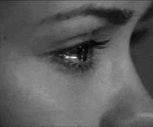 a close up of a woman 's eye with a tear coming out of it