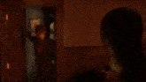 a close up of a person 's face in a dark room with a lamp in the background