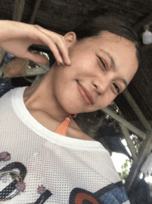 a girl wearing a white shirt with the word disney on it smiles for the camera