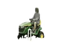a blurry picture of a person riding a green lawn mower