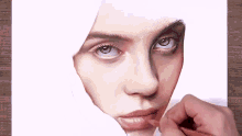 a close up of a person drawing a woman 's face with a pencil