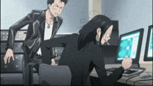 a man smoking a cigarette while another man looks at a computer monitor