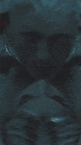 a close up of a person 's face in a dark room with blue eyes