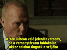 a man in a suit and tie is speaking in a foreign language
