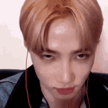 a close up of a person making a funny face while wearing earphones .
