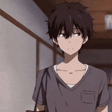 a boy with black hair is wearing a grey shirt with a pocket on the front