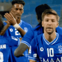 a group of soccer players wearing blue jerseys with the number 10 on the front