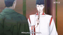 a man in a kimono is holding a sword and talking to another man in a room .