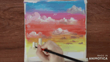 a person is painting a sunset with a brush and made in animatica